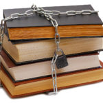 stack of various books wrapped by chain with padlock isolated on white background